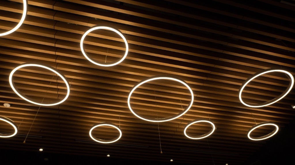 Custom halo pendant lights installed on a slatted wood ceiling